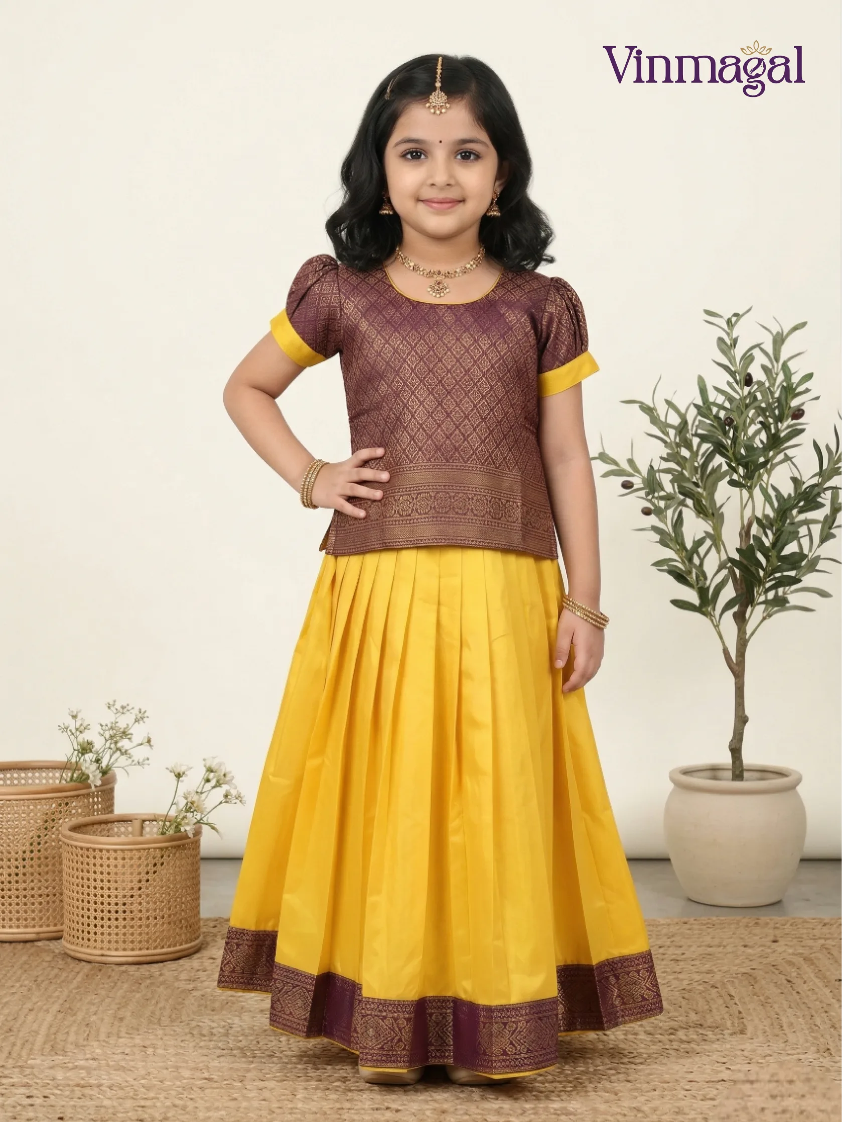 Little girl wearing yellow and purple soft silk pattu pavadai at a festive occasion