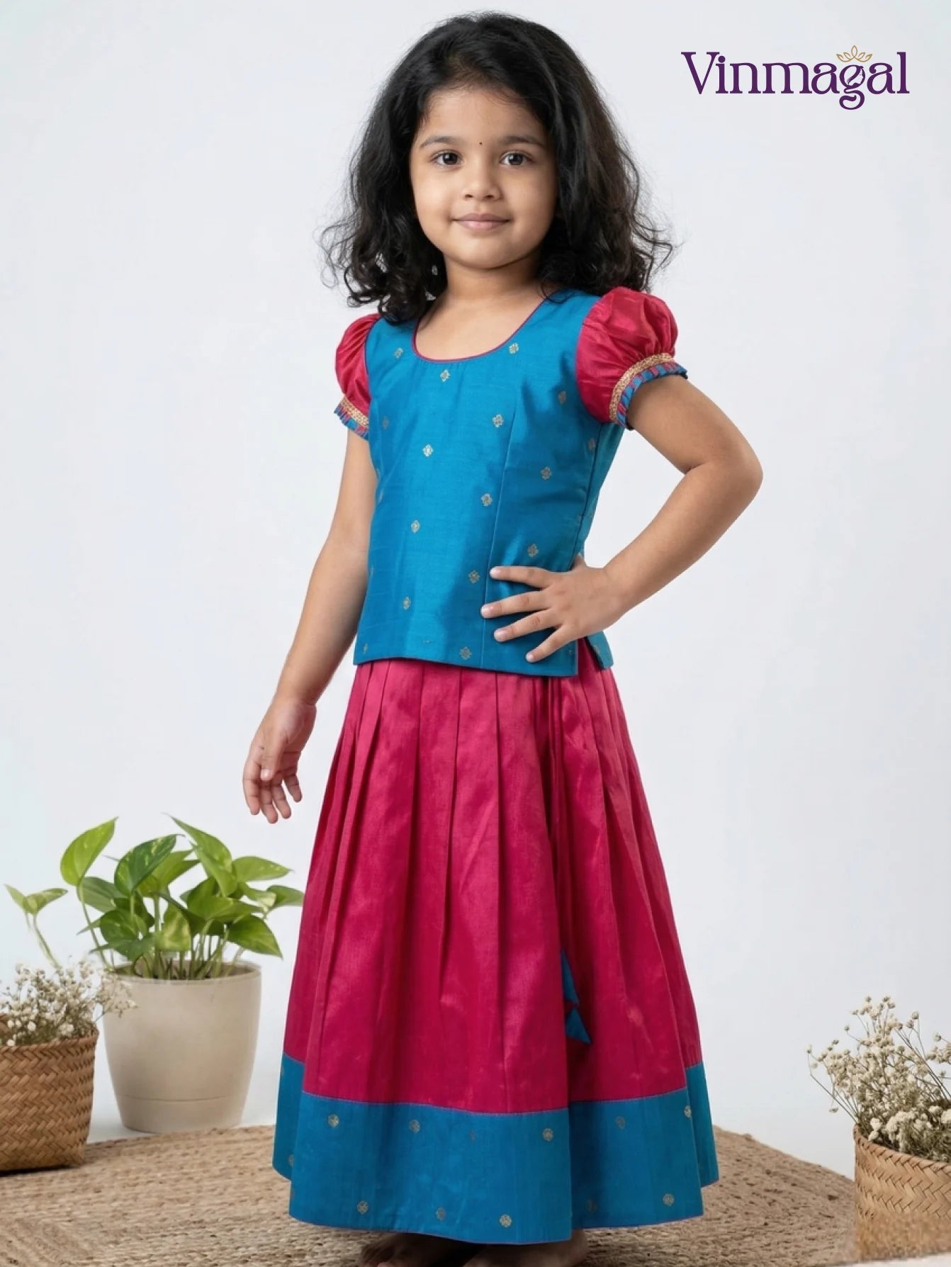 Young girl wearing a blue and pink traditional outfit with 'Vinmagal' branding.