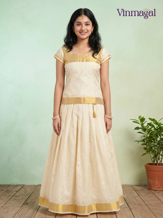 all cream kerala pattu pavadai with golden zari finish for girls